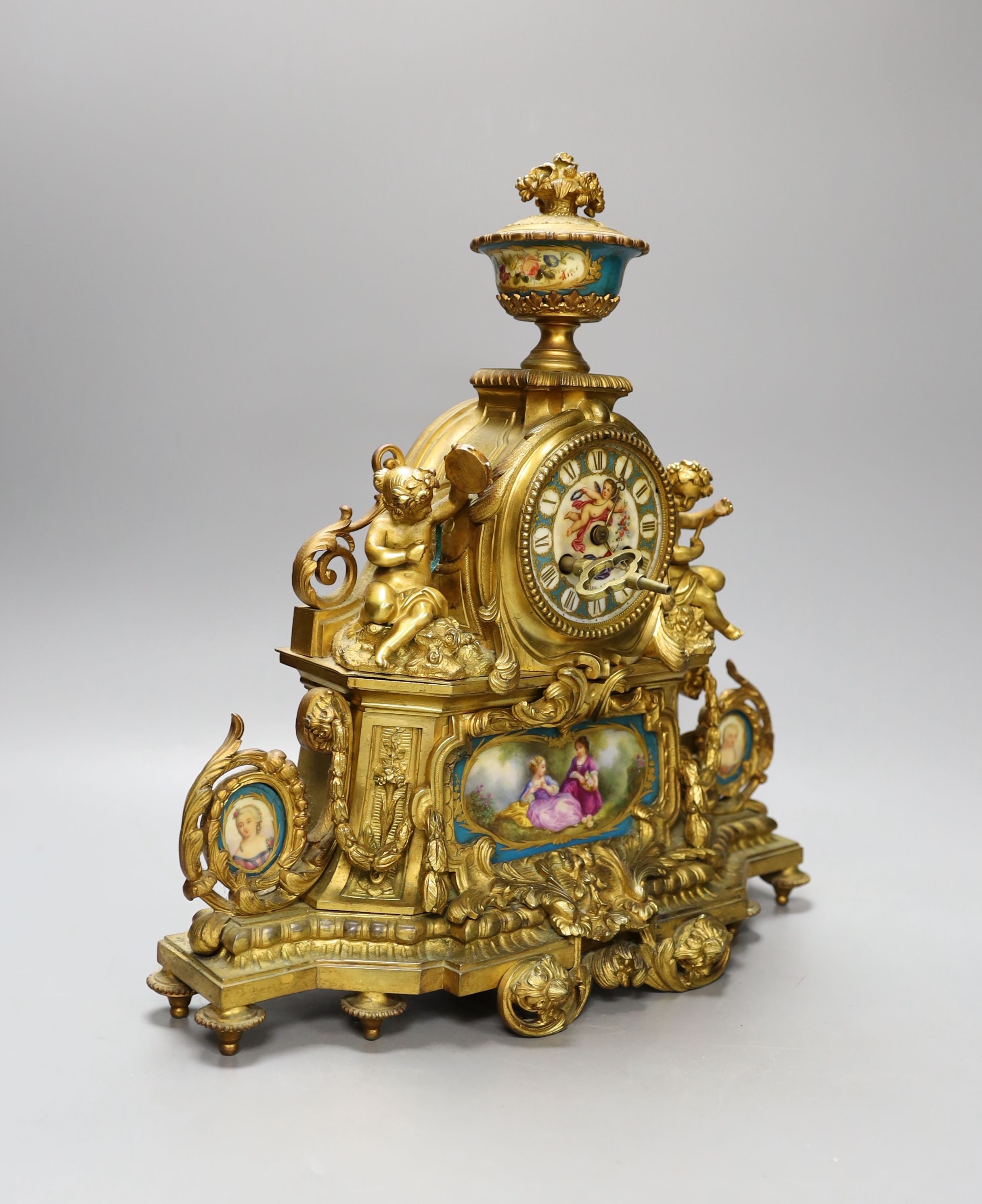 A 19th century French ormolu and Sevres style porcelain mounted mantel clock, with key and pendulum, 35 cm high